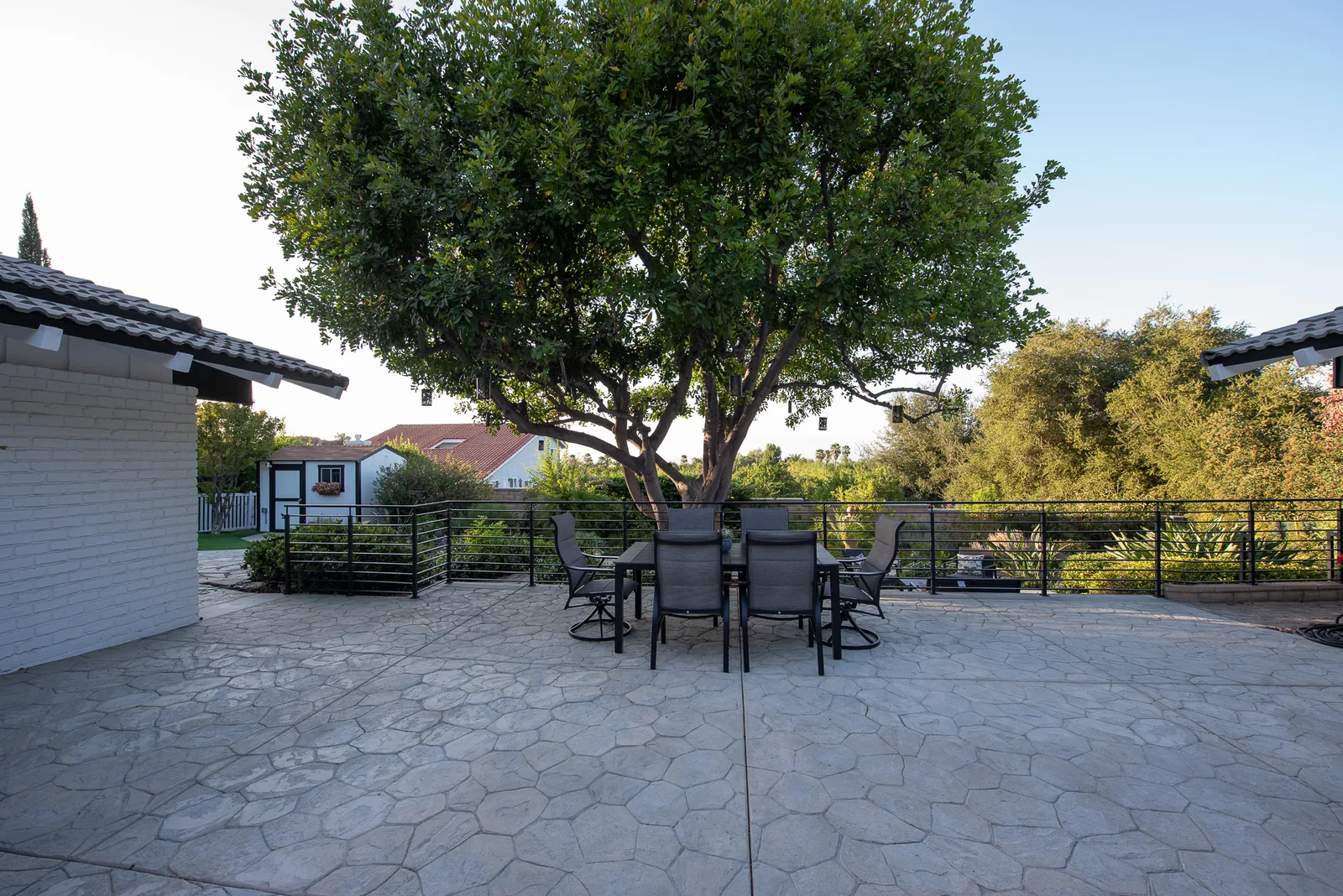 Shaded patio dining area beneath a mature tree at Crown Ranch in Corona, California
